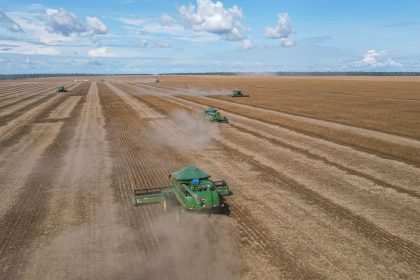 Colheitadeiras trabalham em uma lavoura de soja em uma fazenda no Brasil.